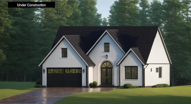 view of front facade with a garage, french doors, decorative driveway, and a front yard