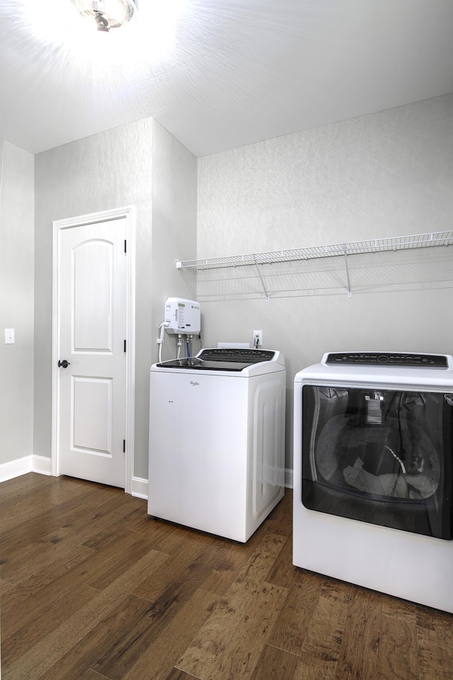 laundry area with dark wood-type flooring, washer and dryer, laundry area, and baseboards