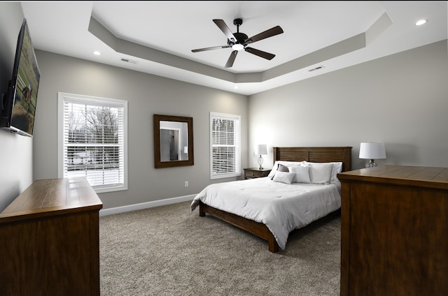 bedroom featuring visible vents, baseboards, a raised ceiling, carpet floors, and recessed lighting