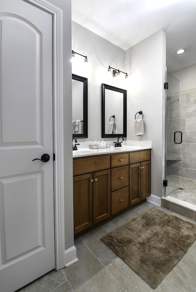 bathroom with tile patterned floors, a sink, a shower stall, and double vanity