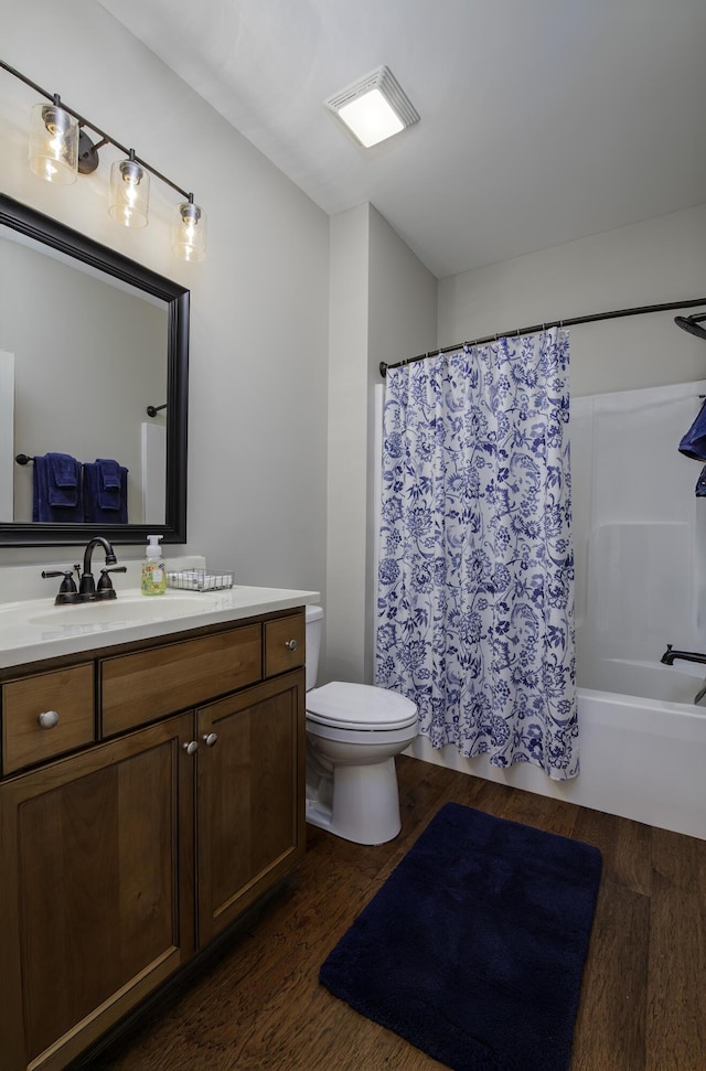 bathroom with toilet, wood finished floors, vanity, and shower / bathtub combination with curtain