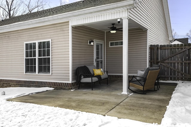 snow covered patio with fence and a ceiling fan