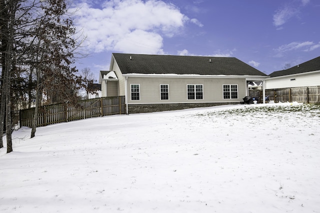 snow covered property with fence