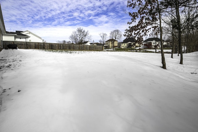 yard layered in snow featuring fence