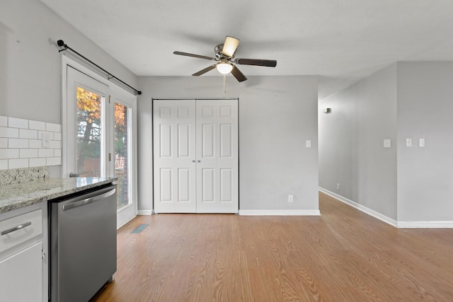 kitchen featuring baseboards, white cabinets, light wood-type flooring, dishwasher, and tasteful backsplash