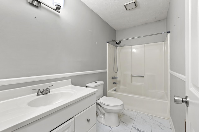 full bath featuring marble finish floor, bathtub / shower combination, toilet, vanity, and a textured ceiling