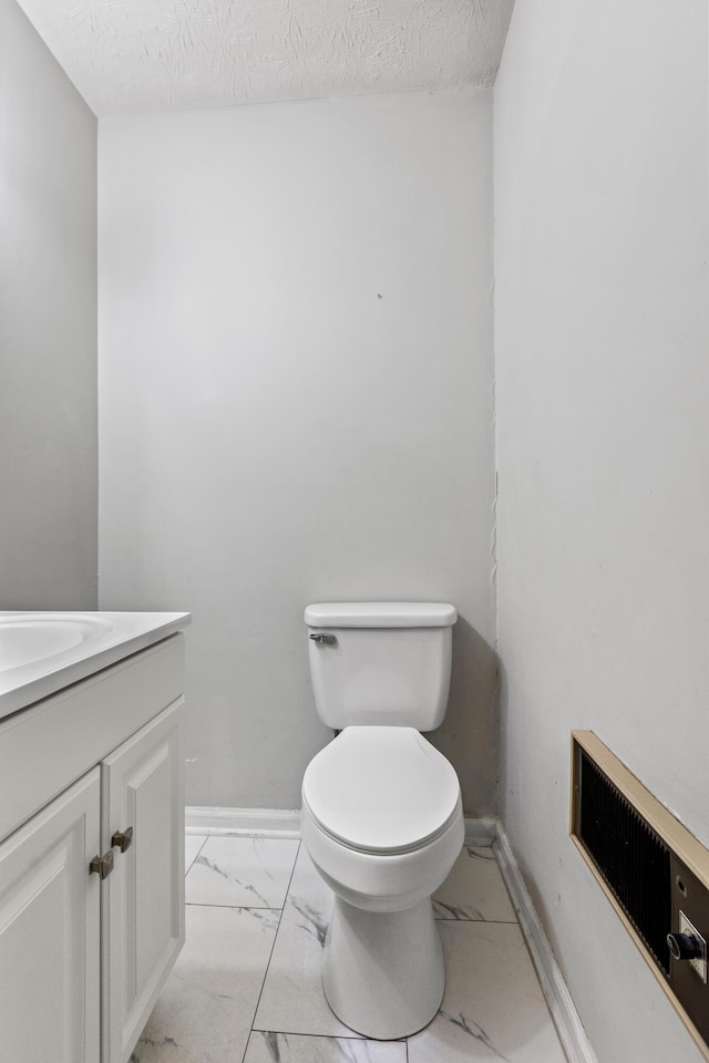 bathroom featuring marble finish floor, visible vents, toilet, vanity, and baseboards