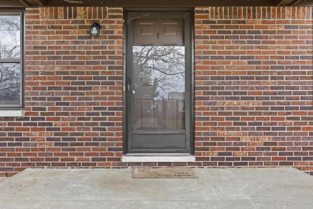 doorway to property with brick siding