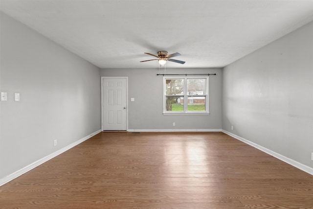 unfurnished room featuring ceiling fan, baseboards, and wood finished floors