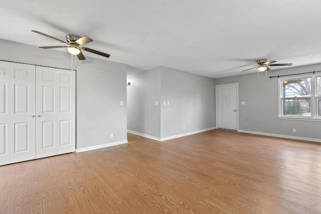 unfurnished living room with light wood-type flooring, baseboards, and a ceiling fan