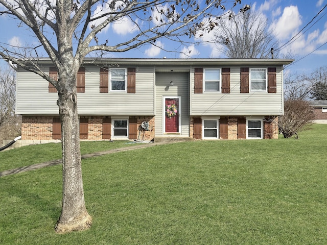 split foyer home with brick siding and a front yard