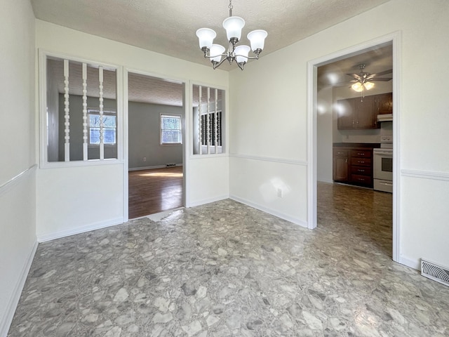 unfurnished dining area with a textured ceiling, ceiling fan with notable chandelier, visible vents, and baseboards