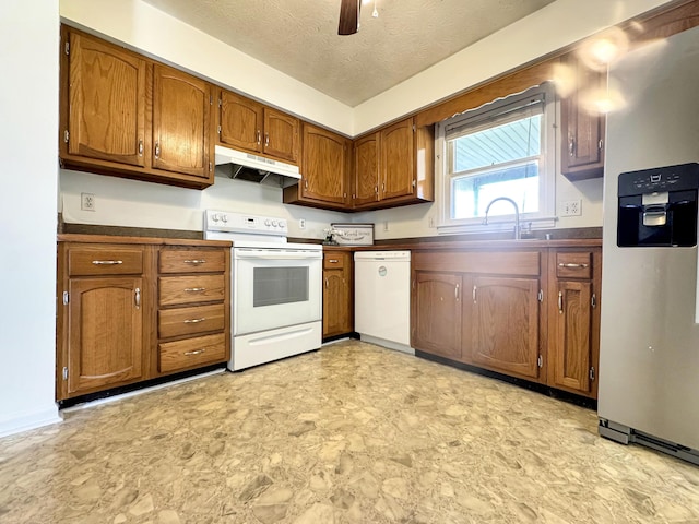 kitchen featuring dark countertops, white appliances, under cabinet range hood, and brown cabinetry