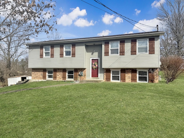 split foyer home featuring a front lawn and brick siding