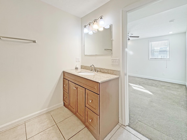 bathroom with a ceiling fan, vanity, baseboards, and tile patterned floors