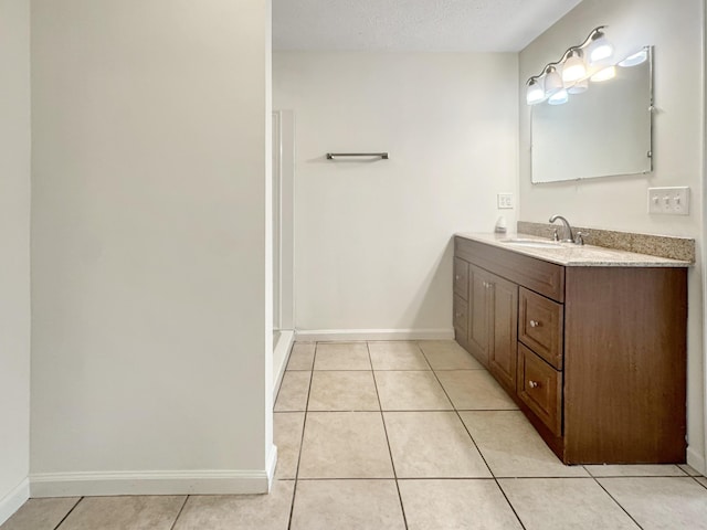 bathroom with baseboards, a textured ceiling, vanity, and tile patterned floors