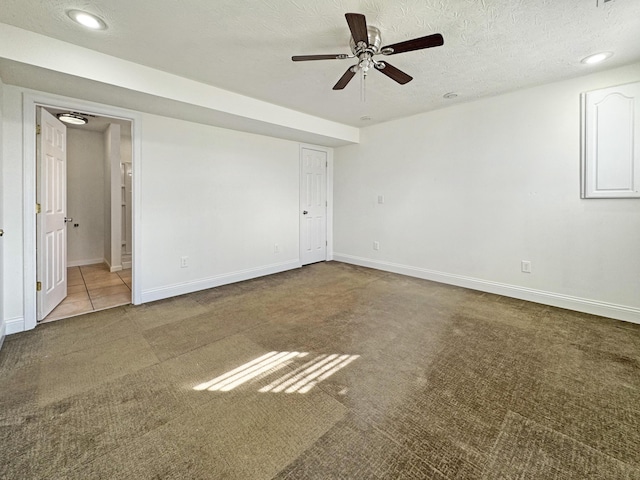 unfurnished bedroom with a textured ceiling, recessed lighting, light colored carpet, baseboards, and ensuite bath