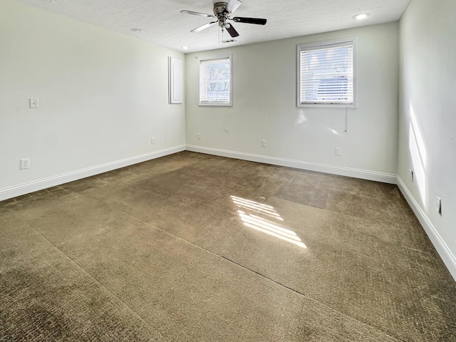 spare room with a textured ceiling, a ceiling fan, and baseboards