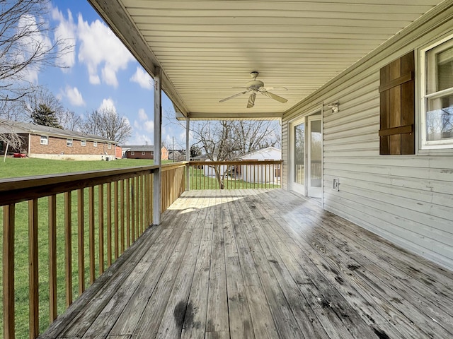 wooden deck with ceiling fan and a lawn