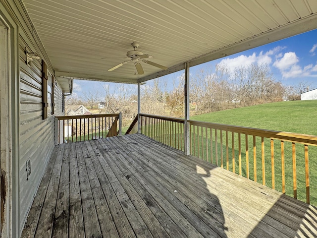 wooden deck with ceiling fan and a lawn