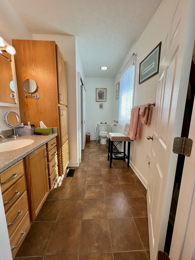 bathroom featuring tile patterned flooring, baseboards, a bidet, and toilet