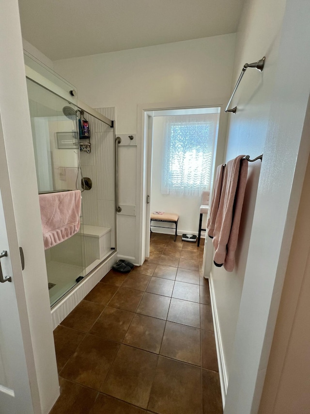 full bathroom featuring tile patterned flooring and a shower stall