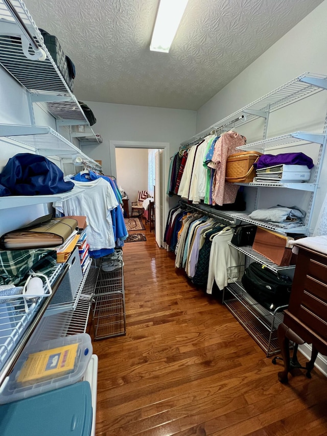 walk in closet with dark wood-type flooring