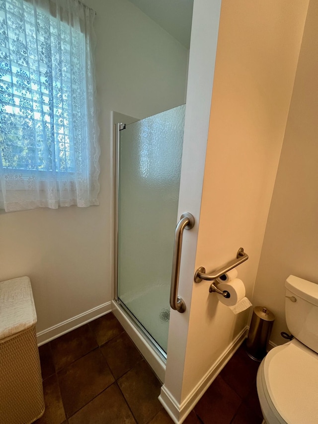 full bathroom featuring tile patterned flooring, a shower stall, toilet, and baseboards