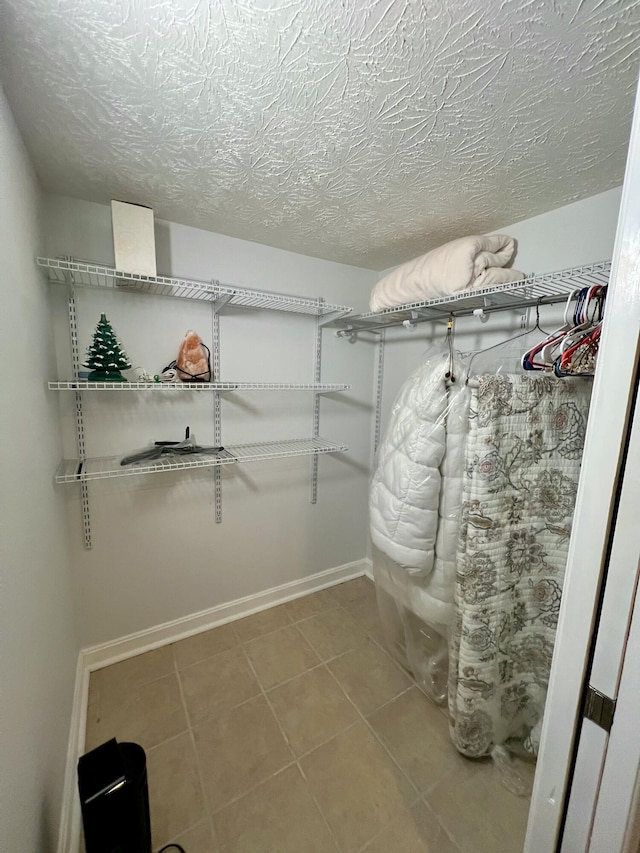 walk in closet with light tile patterned floors