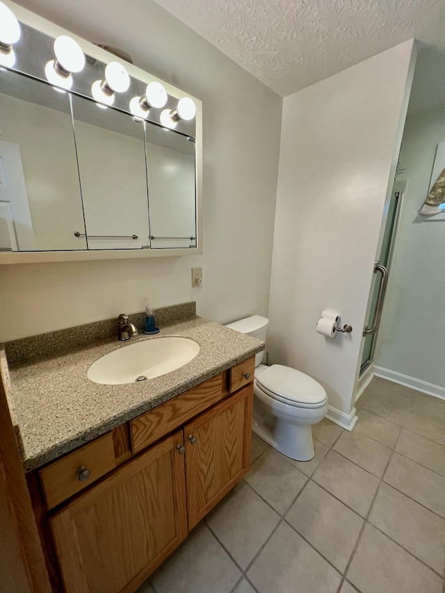 bathroom featuring toilet, a shower stall, vanity, a textured ceiling, and tile patterned floors