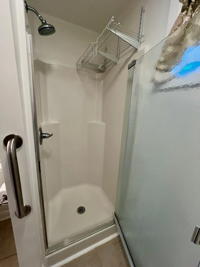 full bath featuring a stall shower and tile patterned flooring