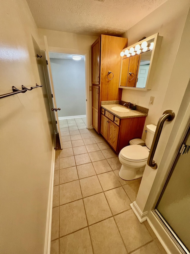 bathroom featuring toilet, an enclosed shower, a textured ceiling, vanity, and tile patterned flooring