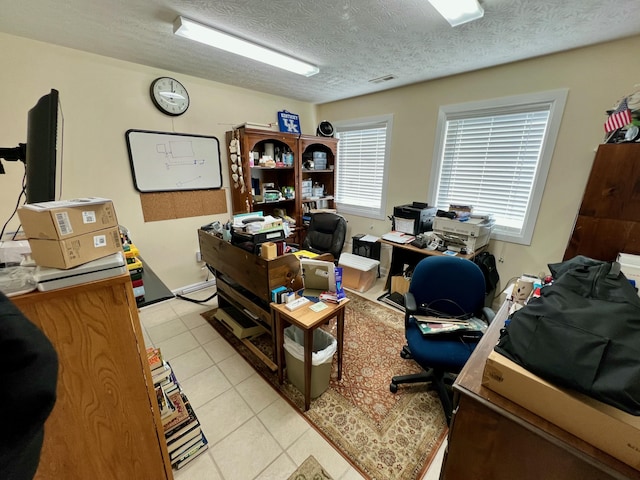 office space featuring light tile patterned floors, visible vents, and a textured ceiling