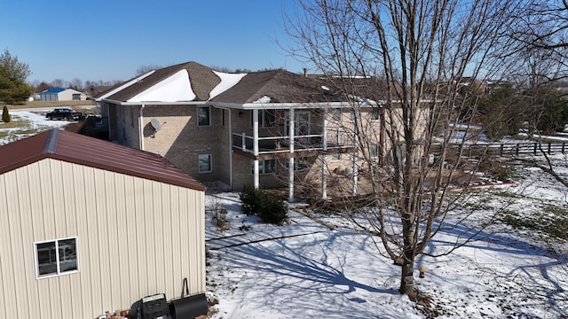 view of snow covered exterior with brick siding