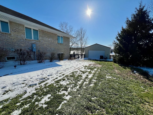 snowy yard with a garage and an outdoor structure