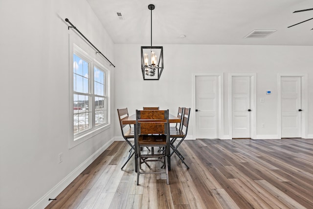 dining room featuring visible vents, baseboards, and wood finished floors