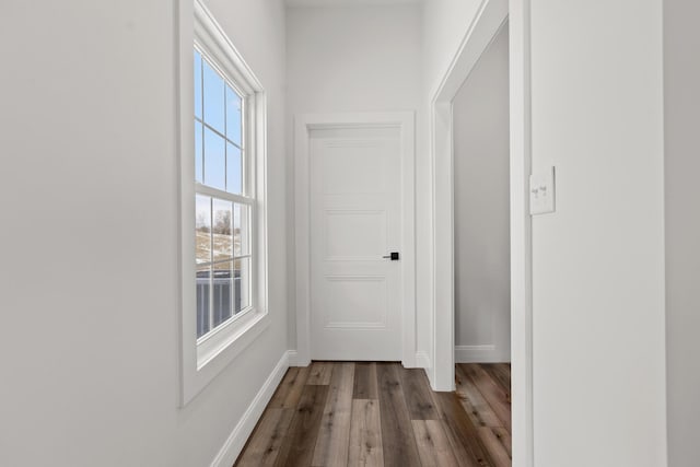 hall featuring baseboards and wood finished floors