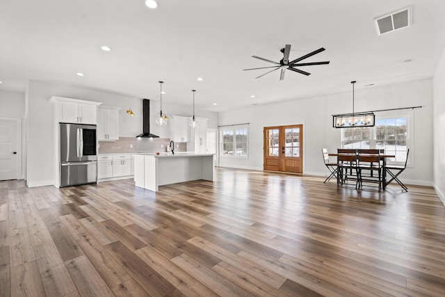 unfurnished living room with recessed lighting, visible vents, plenty of natural light, and wood finished floors