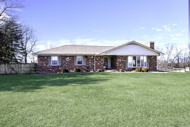 ranch-style house featuring a chimney, fence, a front lawn, and brick siding