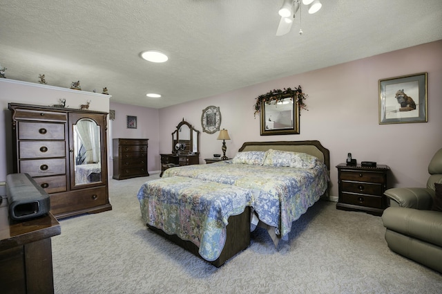 bedroom with a textured ceiling, carpet floors, and ceiling fan