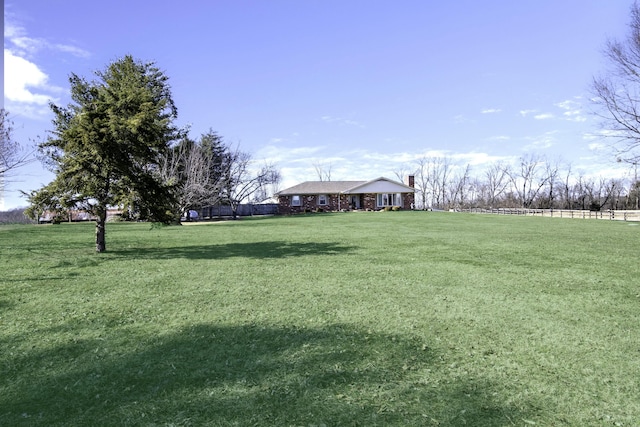 view of yard featuring fence and a rural view