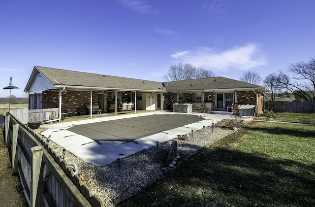 back of house with a patio area, brick siding, a lawn, and fence