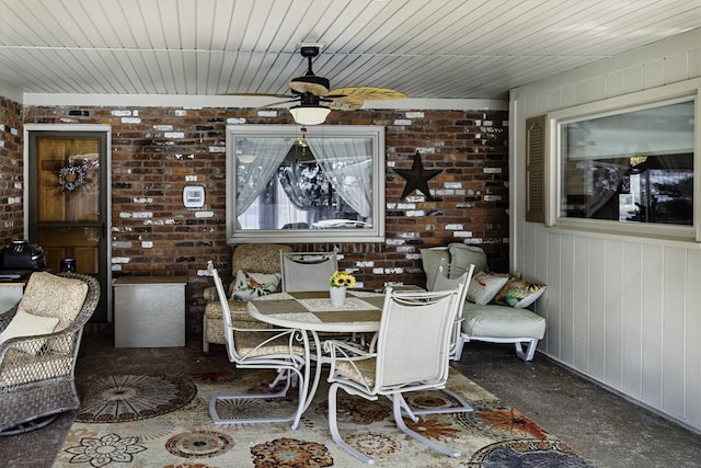 dining room featuring brick wall, wooden ceiling, and a ceiling fan