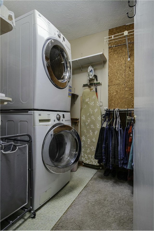 laundry area with a textured ceiling, laundry area, stacked washer and dryer, and light carpet