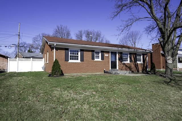 view of front of house featuring a front yard, brick siding, and fence