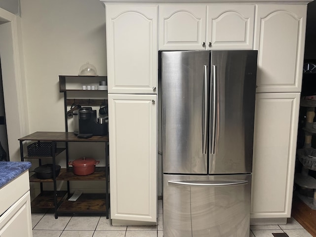 kitchen featuring freestanding refrigerator and white cabinets