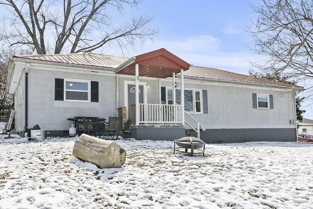 view of front of house featuring metal roof and a fire pit