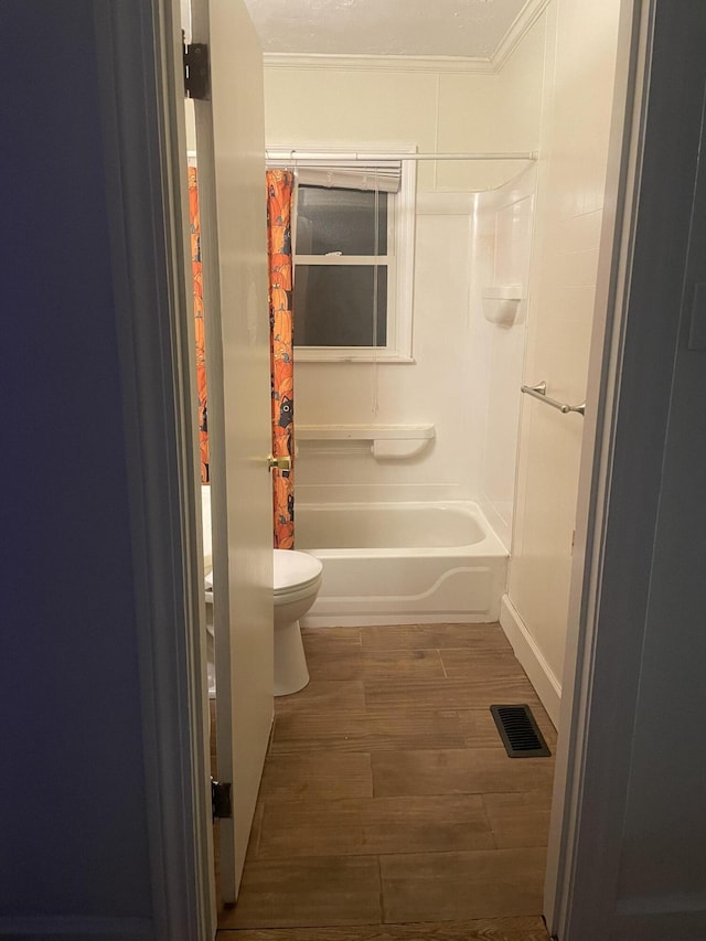 bathroom with visible vents, toilet, ornamental molding, wood finished floors, and shower / bath combination with curtain