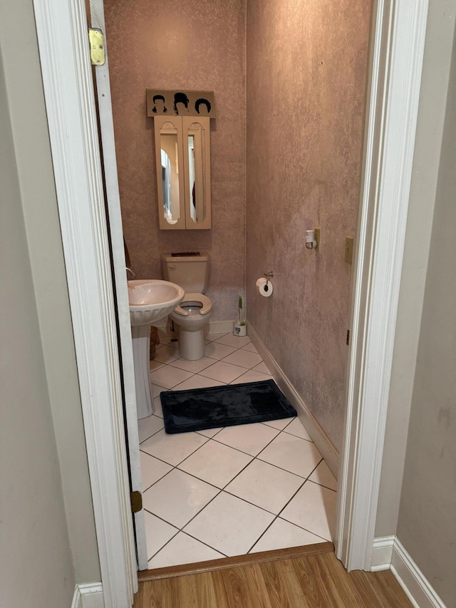 bathroom featuring toilet, tile patterned floors, and baseboards
