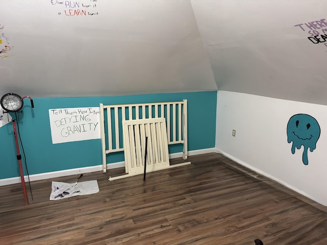 additional living space featuring lofted ceiling, dark wood-style flooring, and baseboards